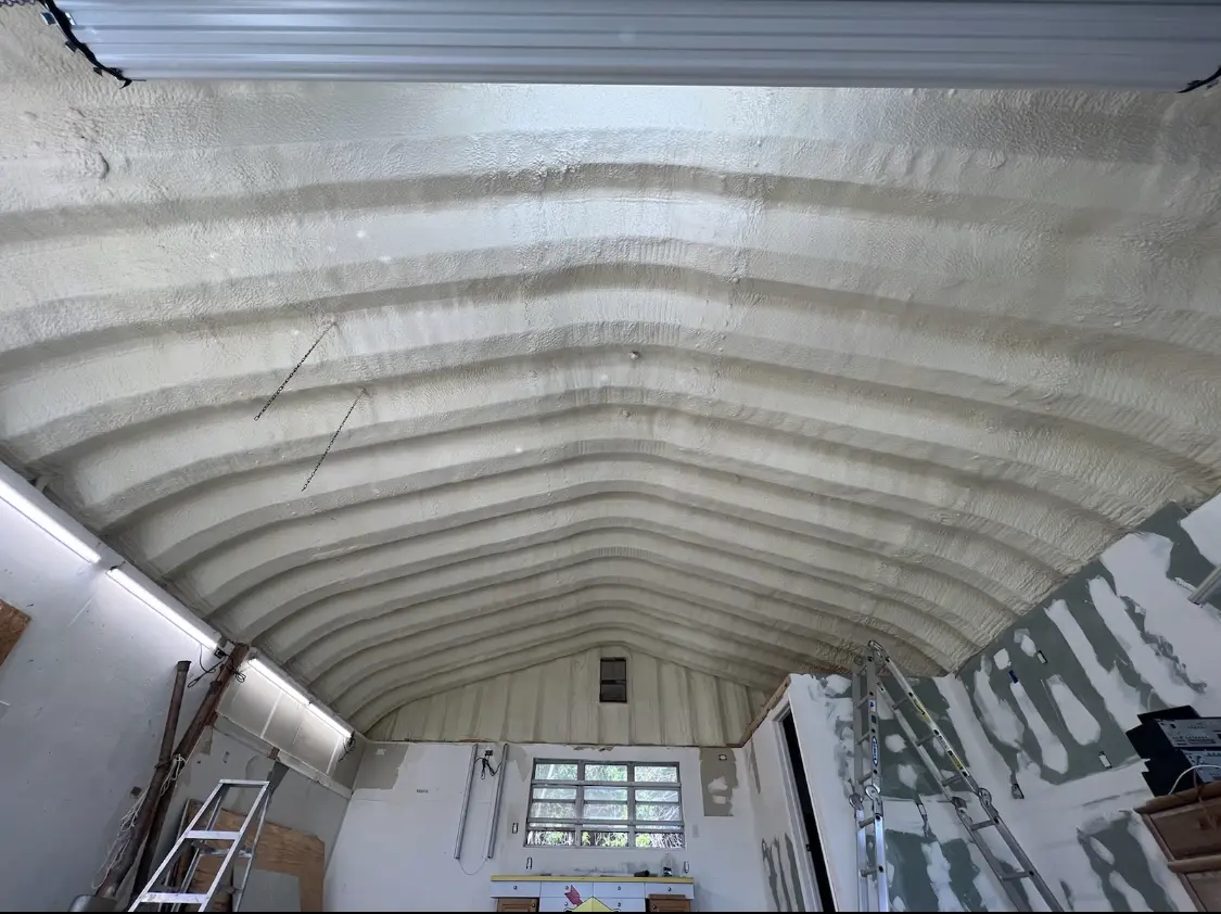 Spray polyurethane foam applied to the underside of a metal roof deck in Falls